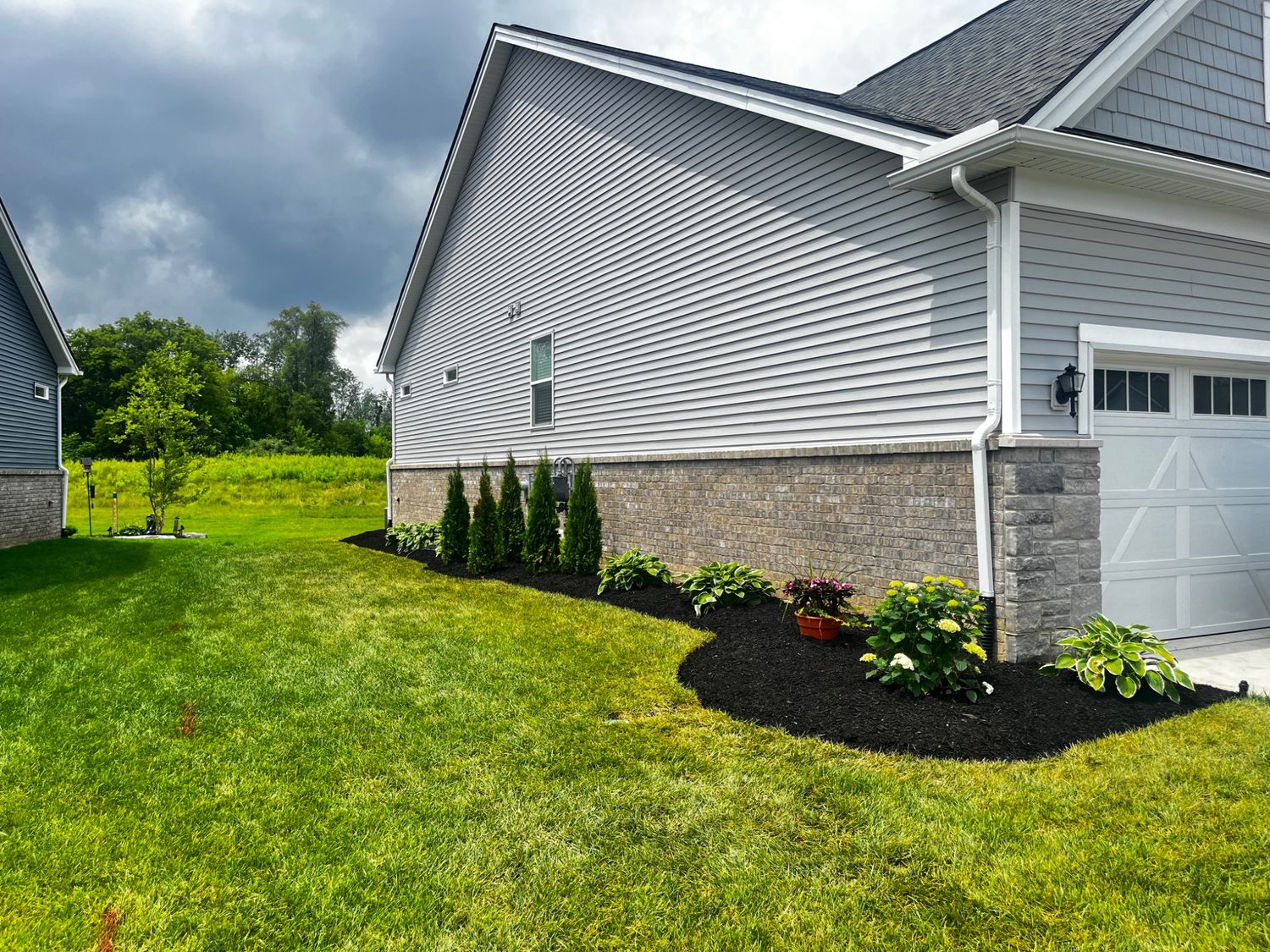 After photo of finished side yard landscape bed with plants and mulch